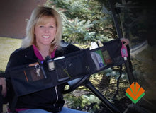 Person holding a black organizer with various items in front of a vehicle