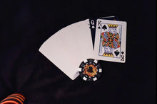 Playing cards and a poker chip on a black background
